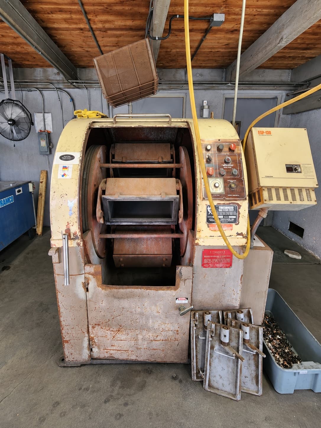 Customer’s original cream-colored finishing machine beneath a low workshop ceiling