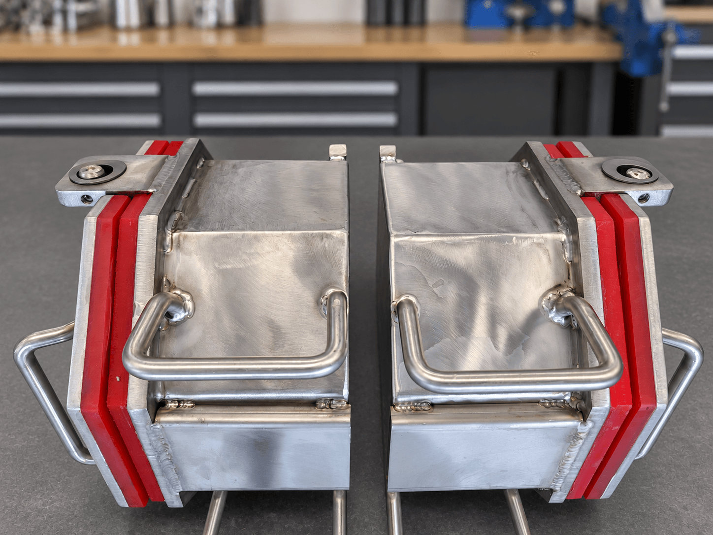 Side view of two CV8-600 one-eighth cubic foot barrels showing stainless construction, handles, and red polyurethane edges