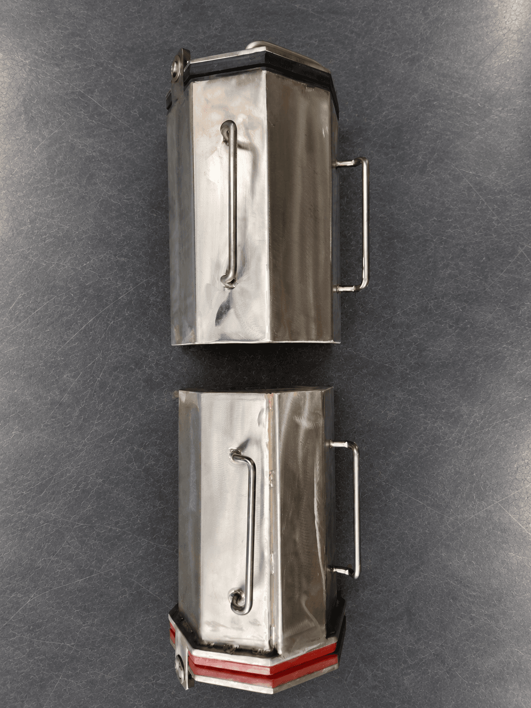 Two closed quarter-cubic-foot stainless barrels showing black rubber and red polyurethane lid edges