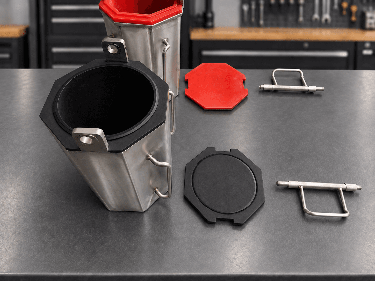 Black rubber-lined quarter-cubic-foot barrel with detached lid and handle, red polyurethane-lined barrel behind