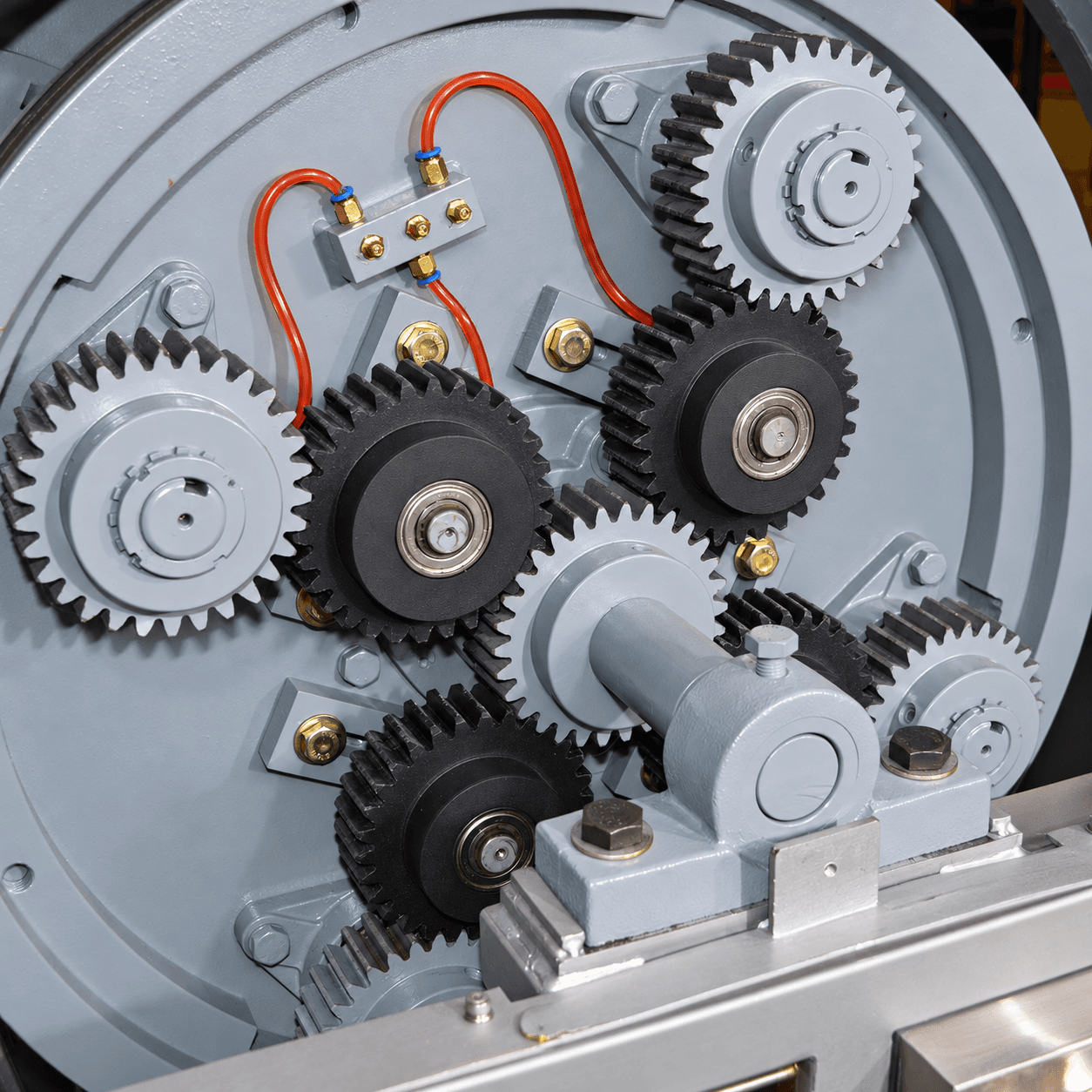 Gear drive with black nylon molybdenum transfer gears and an accessible grease port manifold connected to orange grease lines